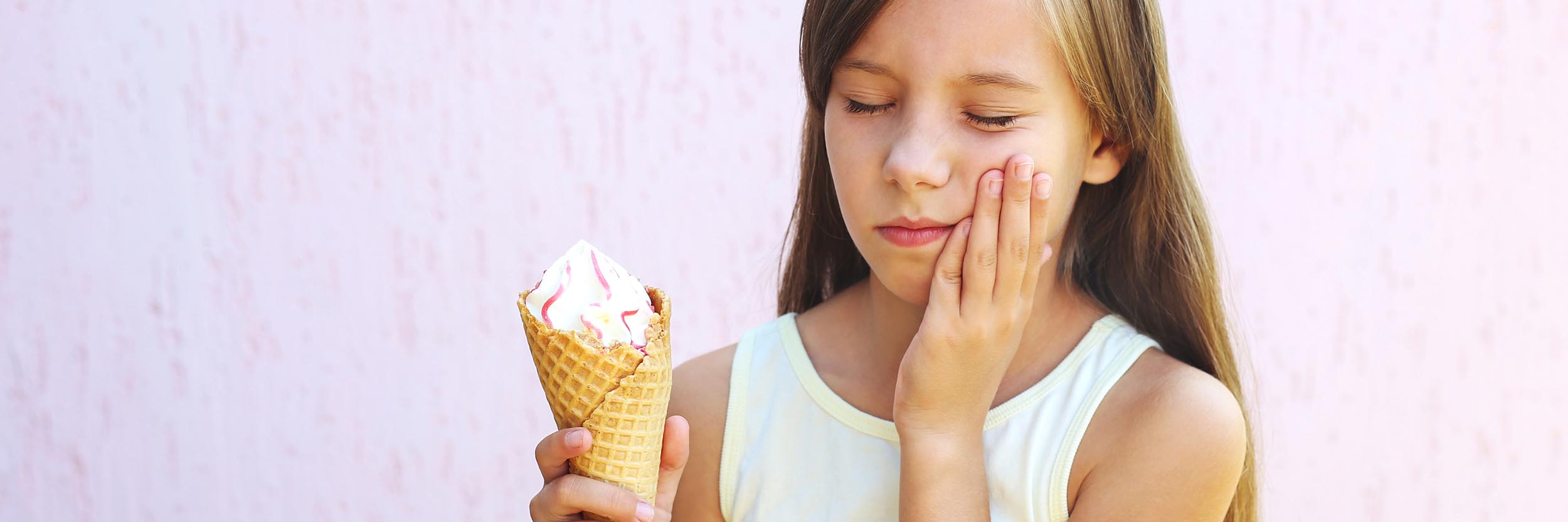 Girl has a toothache from cold ice cream.