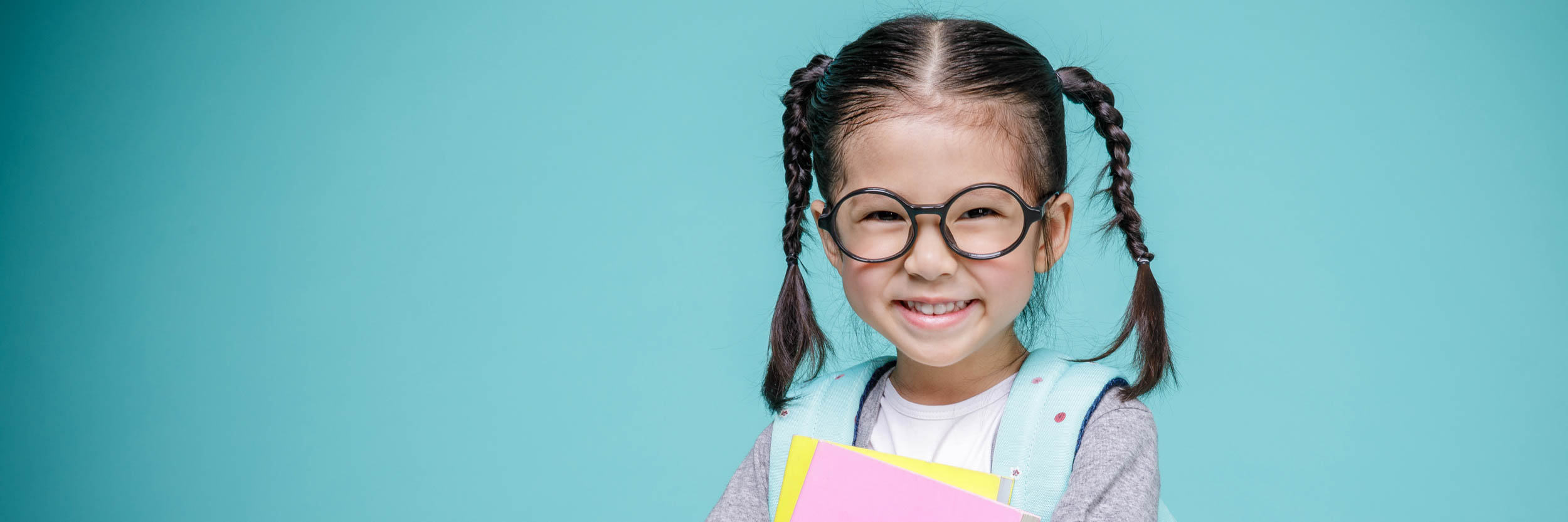 A smiling little girl with glasses