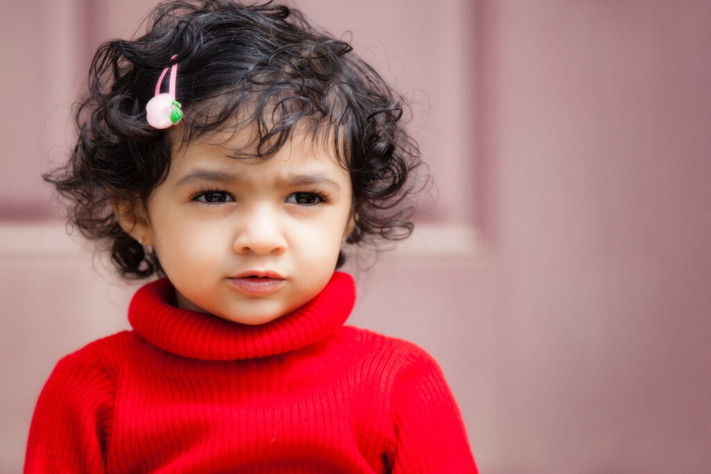 A young girl with dark curly hair