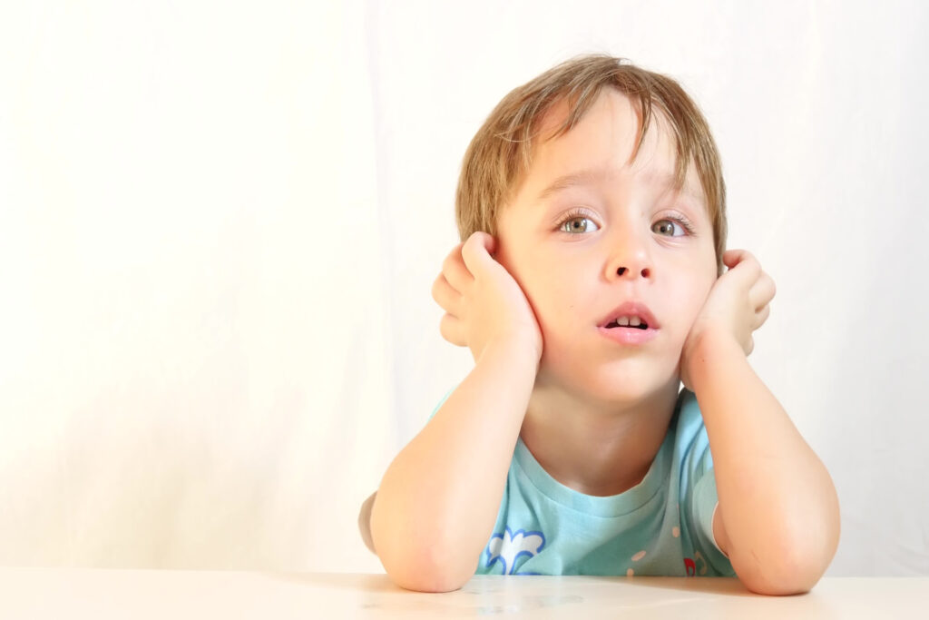 A child holding their head in their hands