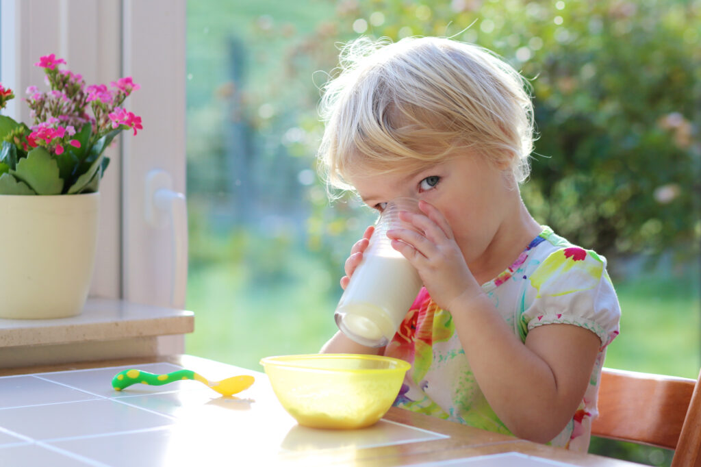 Toddler drinking milk outside