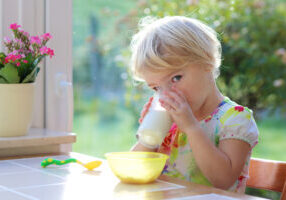 Toddler drinking milk outside